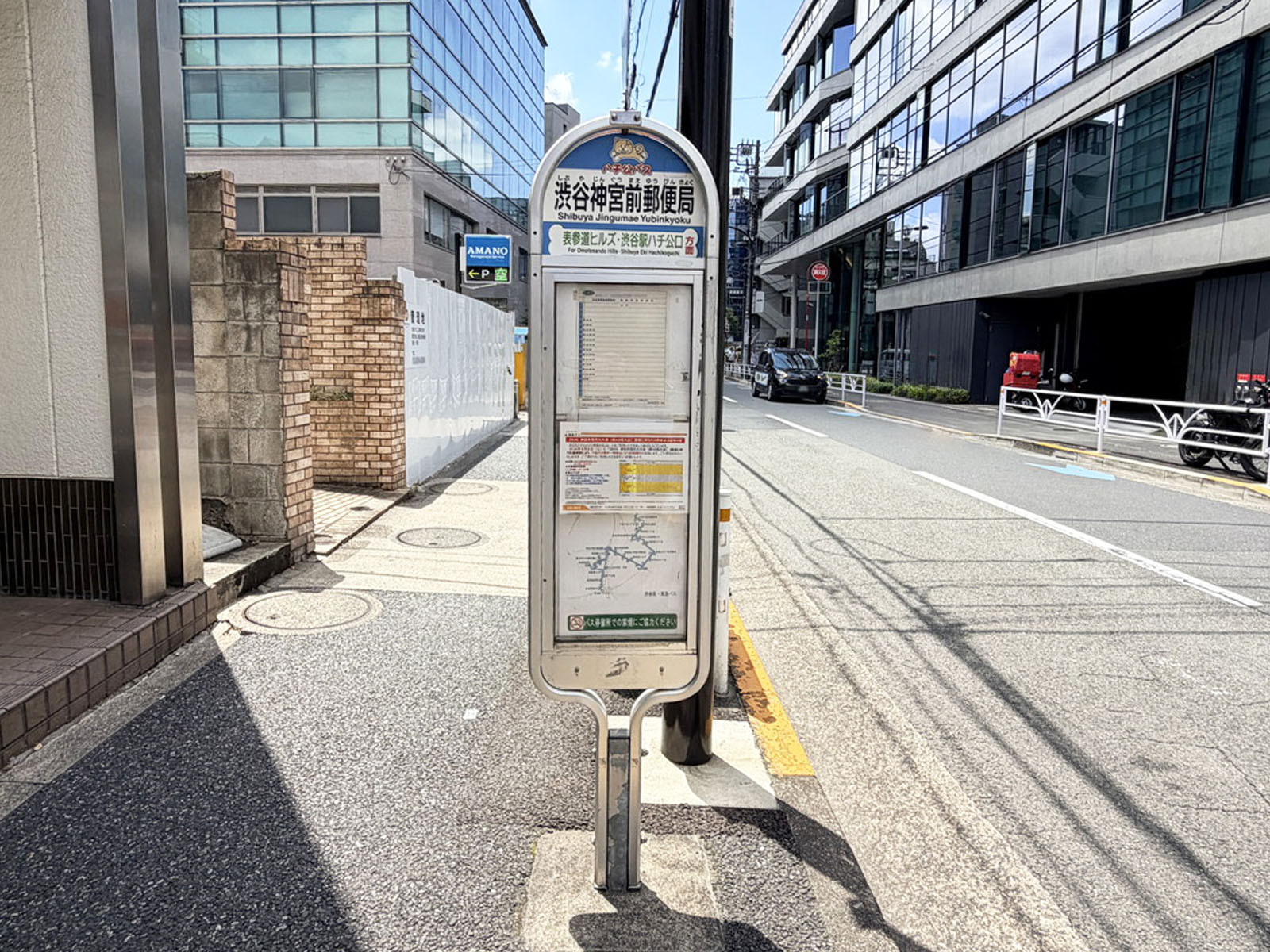ビル前のバス停「渋谷神宮前郵便局」